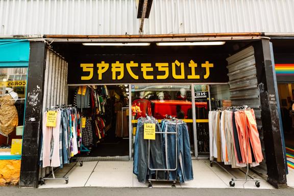 Three clothing racks outside the storefront of Spacesuit, a secondhand clothing store on Cuba Street in Wellington.