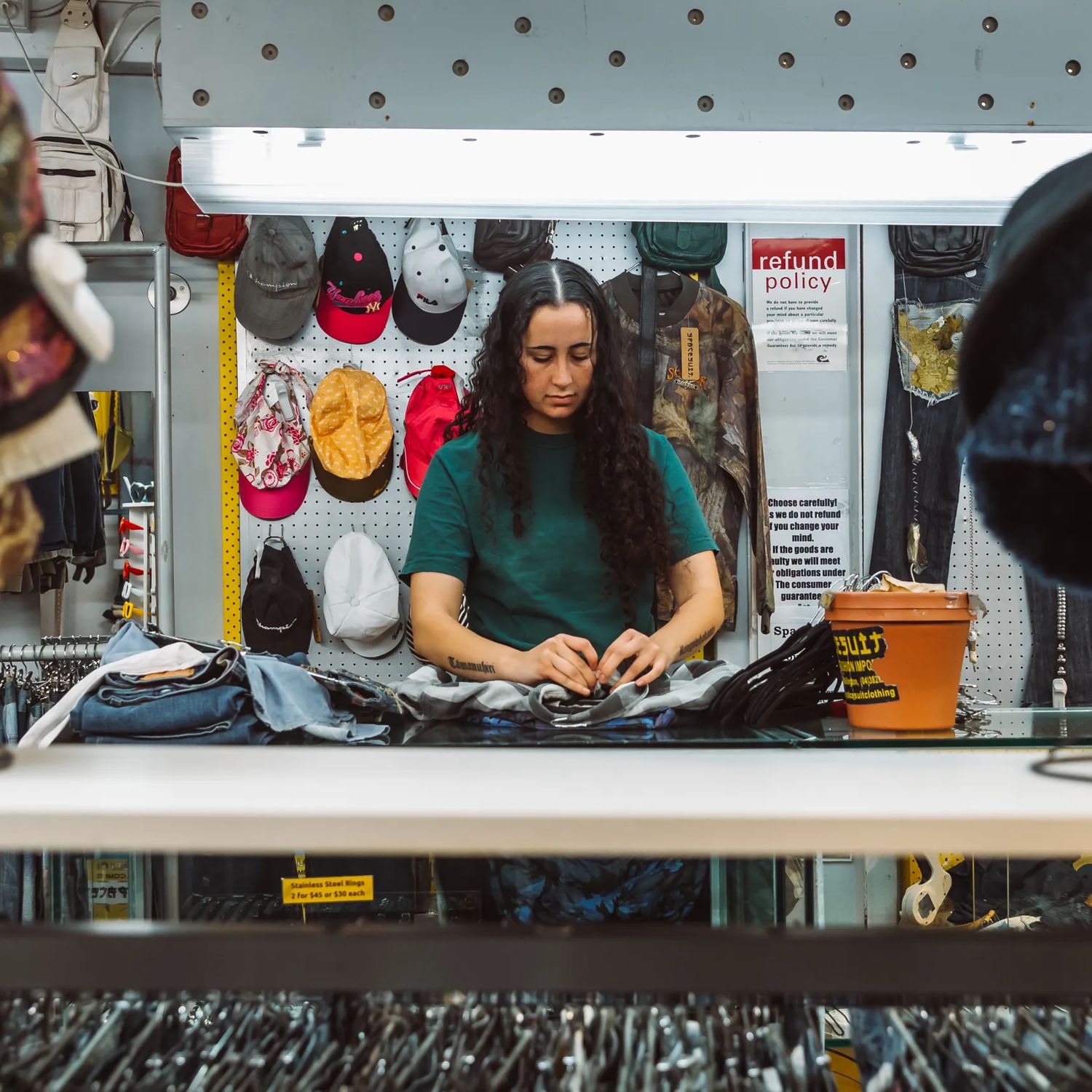 Person sorting clothing behind the counter at Spacesuit on Cuba Street.