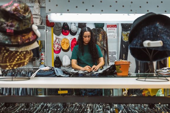 Person sorting clothing behind the counter at Spacesuit on Cuba Street.