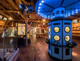 Inside the Wellington Museum , a large box with a roof sits in the front with old telephones, going back in time. Other exhibitions sit around the room.