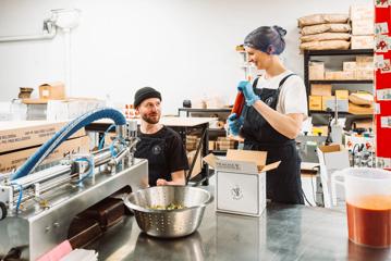 Lydia Harfield and Mat Watkins, co-founders of Apostle Hot Sauce, work in their test kitchen.