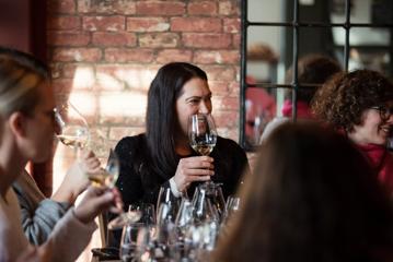 A group of young professionals do a wine tasting at Noble Rot wine bar.