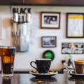 Three types of coffee, in different vessels, sit on the counter in Black Coffee in Newtown. Framed pictures are blurred on the walls in the background.