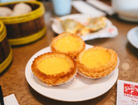 Three small lemon tarts on a plate.