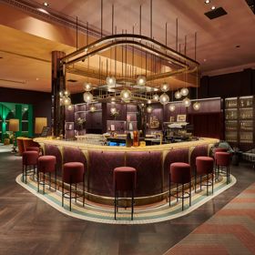 A swanky hotel bar with colourful art deco decor and low lighting.