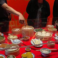 People pointing at a knitted yum cha banquet.