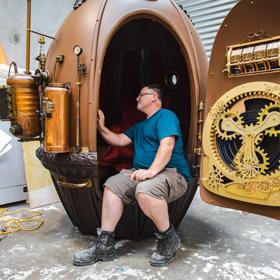 Matt Houghton of Human Dynamo sits and admires the submarine egg-shaped capsule he built for the film Avatar: The Way of the Water.