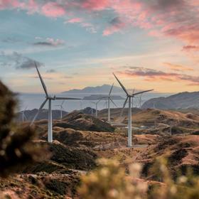 The Mākara Wind Farm located near Mākara Beach during golden hour.