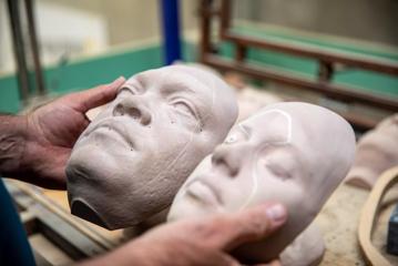 Matt Houghton of Human Dynamo holding two moulded faces created for Avatar: The Way of the Water.