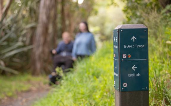 Wayfinding marker on Te Ara o Tipapa showing arrows for the Bird Hide and Te Ara o Tipapa.