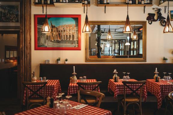 The interior of Nicolini’s, an Italian restaurant off of Courtenay Place in Wellington. The space has a warm atmosphere with wooden chairs, red and white checkered table clothes and rustic antique décor.