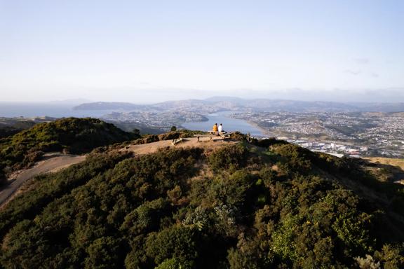 Two people sit on the bench at the Rangituhi Lookout.