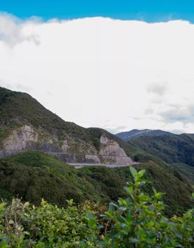 The screen location of Remutaka Summit, wit views of surrounding peaks, lush green bush and steep roads cut into the sides of the mountains.