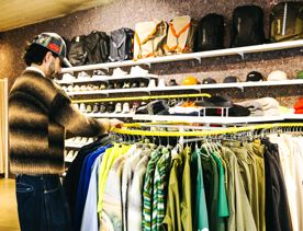 A person looks through a clothing rack at Good As Gold.