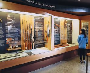 A person looking at weapons on display at the New Zealand Police Museum.