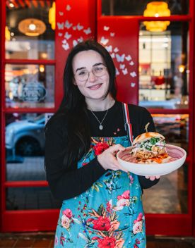 A person holding up a burger at Madama Butterfly in Wellington