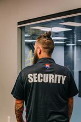 A member of the Red Badge Group facing away from the camera to show their 'Security' logo on their back.