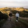Two people walk up a hill on Farm Road to Rangituhi Summit.