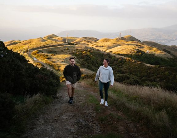 Two people walk up a hill on Farm Road to Rangituhi Summit.