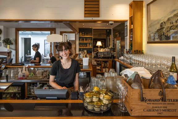 A waiter inside Thistle inn smiling at the camera.