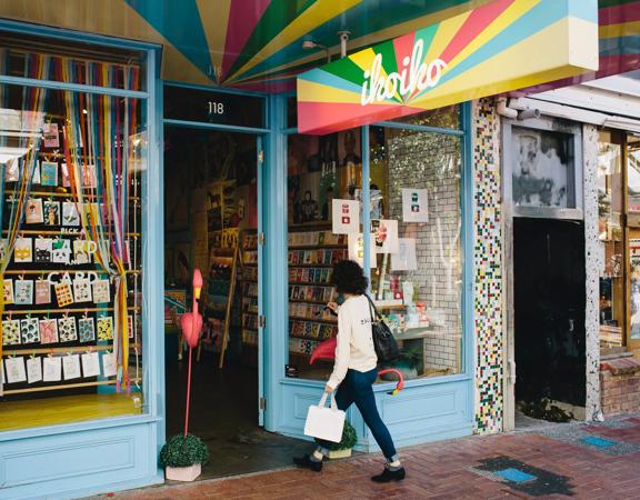 The vibrant exterior of Iko Iko with a person walking inside.