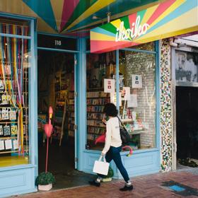 The vibrant exterior of Iko Iko with a person walking inside.