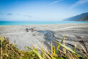 Two cyclists on the beach in Palliser Bay, at the entrance to the Wild Coast Section of the Remutaka Cycle Trail.