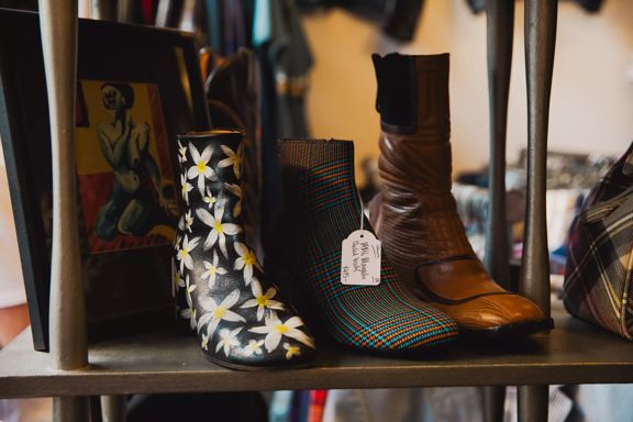 Patterned and leather boots displayed on a shelf at Hunters & Collectors in Wellington.
