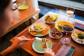 Looking over the shoulder of a customer eating food in Graze Wine Bar.