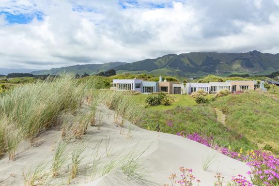 On the sand dunes looking over to Atahuri Lodge on the Kāpiti Coast, with mountains in the background.