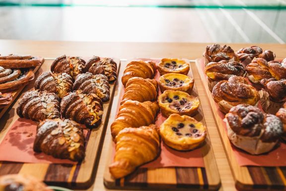 Croissants, pastries, and muffins inside a cabinet at Volco, Kelburn.