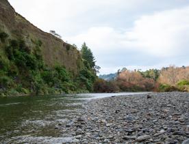 The screen location of Te Mārua  cliffs, where a river flows against vertical cliffs on the foothills of the Remutaka Range.