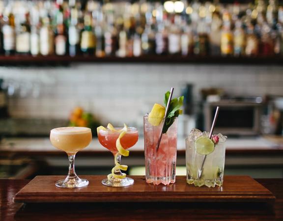 Four colourful cocktails lined up on the counter at Crumpet, a bar located on Manners Street in Te Aro, Wellington. 