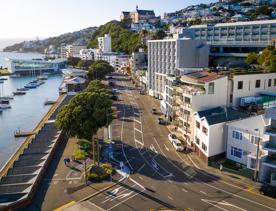 The screen location of Oriental Bay, wth pastel-coloured, Art Deco apartments, brightly-painted boat sheds, and the golden beach.