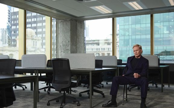 Shayne P Carter sits in an empty, modern, open-concept office.