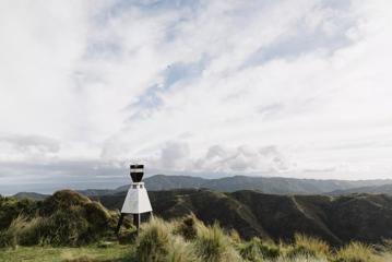 A trig beacon on a grassy mountain summit in Te Kopahou Reserve.