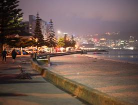 The screen location of Oriental Bay, wth pastel-coloured, Art Deco apartments, brightly-painted boat sheds, and the golden beach.