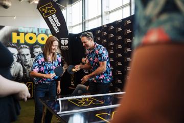 Two people in Hawaiian shirts team up to play doubles table tennis at Beervana.