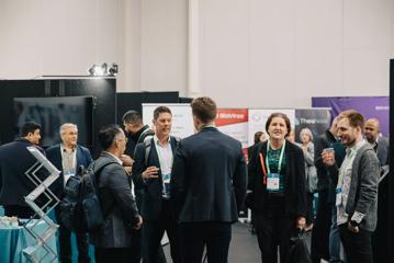 A group of people dressed business-casual standing around at a conference.