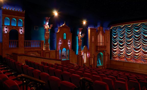A theatre at Park Road Post Production with red seats, and blue and purple lighting.
