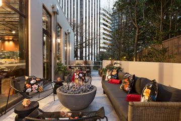 The inner-city outdoor balcony at Sofitel Wellington with comfortable chairs and a fire pit