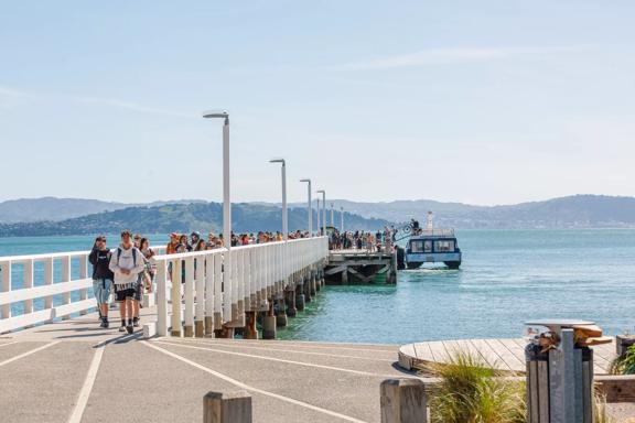 Passengers disembark the East By West Ferry on the Days Bay wharf.