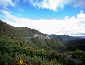 The screen location of Remutaka Summit, wit views of surrounding peaks, lush green bush and steep roads cut into the sides of the mountains.