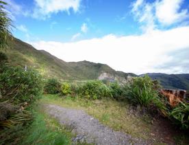 The screen location of Remutaka Summit, wit views of surrounding peaks, lush green bush and steep roads cut into the sides of the mountains.