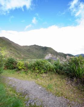 The screen location of Remutaka Summit, wit views of surrounding peaks, lush green bush and steep roads cut into the sides of the mountains.