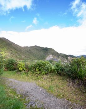 The screen location of Remutaka Summit, wit views of surrounding peaks, lush green bush and steep roads cut into the sides of the mountains.