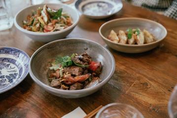 Close-up of a beef dish on a table amongst other dishes at Apache in Wellington.