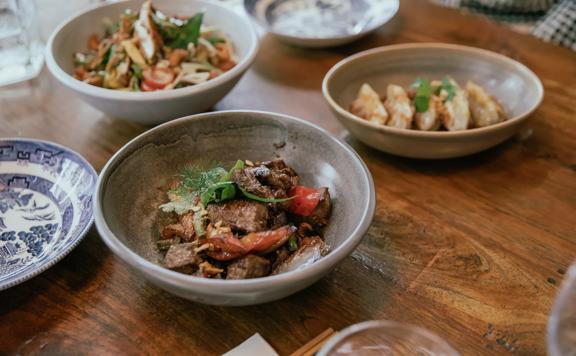 Close-up of a beef dish on a table amongst other dishes at Apache in Wellington.