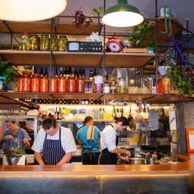 The interior of Graze Wine Bar with bar staff behind the bar.