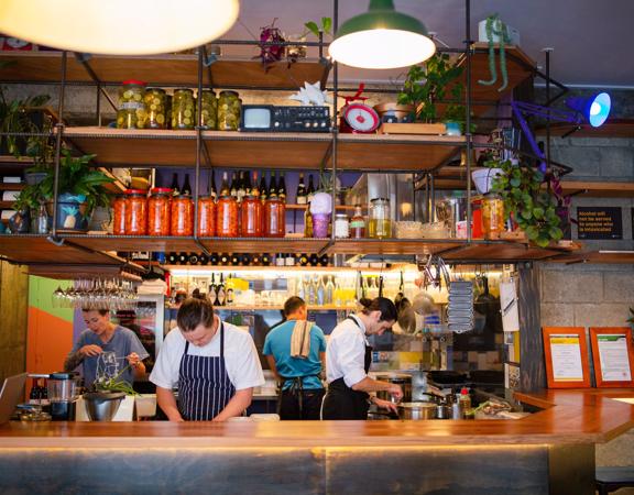 The interior of Graze Wine Bar with bar staff behind the bar.